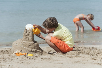 Spanien,Mallorca,Boy (8-9) Sandburgen bauen am Strand,Mädchen (4-5 ) im Hintergrund
