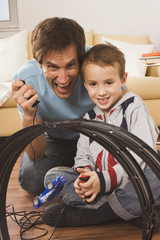 Vater und Sohn ( 4-5) spielt mit Spielzeug- Rennbahn