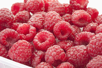 Himbeere in Kunststoff- Container auf weißem Hintergrund