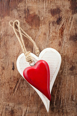 two wooden hearts, red and white on old wooden background © Elena Moiseeva