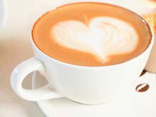 Cup of coffee with heart pattern in a white cup