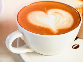 Cup of coffee with heart pattern in a white cup