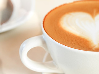 Cup of coffee with heart pattern in a white cup
