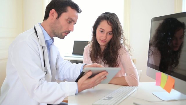 Doctor using tablet to inform patient 