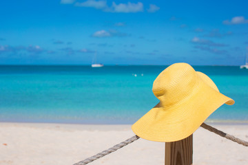 Fototapeta na wymiar Yellow hat on the beach fence at caribbean island