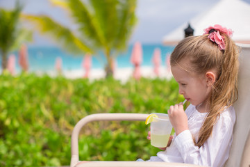 Adorable little girl drinking juice at outdoor cafe