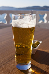 A glass of beer near the sea.