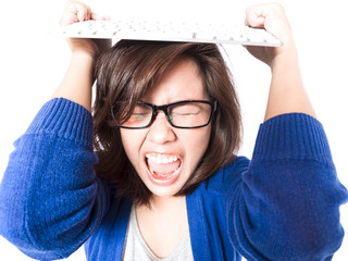 Angry young stress woman with computer keyboard