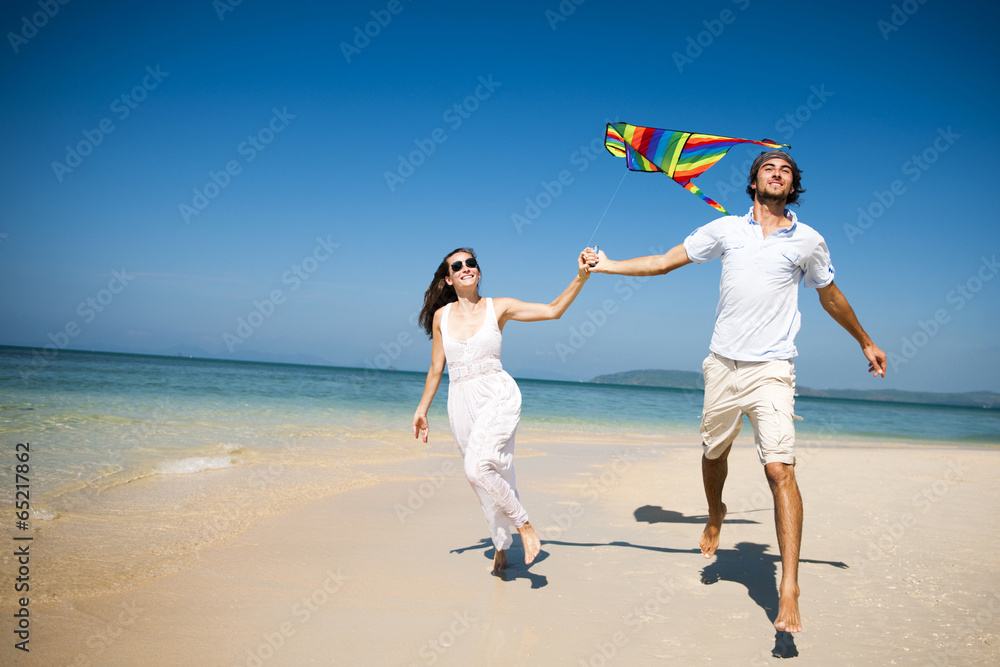 Canvas Prints A couple flying a kite on the beach