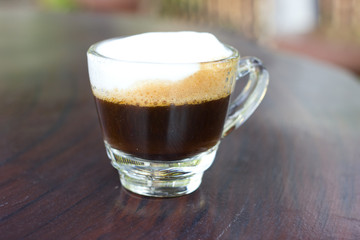Hot  espresso with milk and foam in cup.