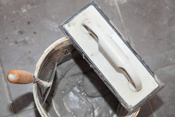 Dirty trowel and bucket on building site. Renovation at home