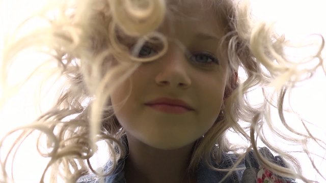 Face of a little girl with ringlets of hair falling down