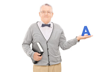 Male teacher holding book and the letter a