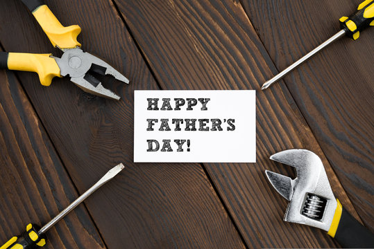 card of HAPPY FATHER'S DAY and tools on wood