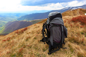 big backpack on meadow in mountains