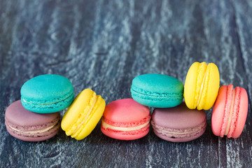 Assorted french macaroons over old wood background.
