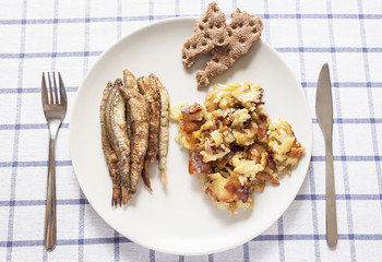 plate of food consisting of fried fish, potatoes and crisp bread