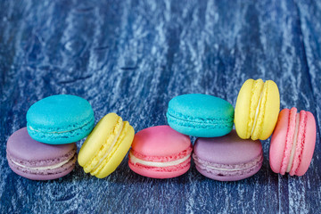 Assorted french macaroons over old wood background.