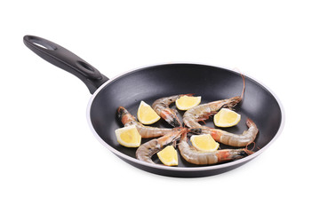 Raw shrimps on pan with lemon.