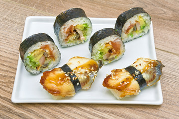 sushi and rolls on a plate on a wooden background
