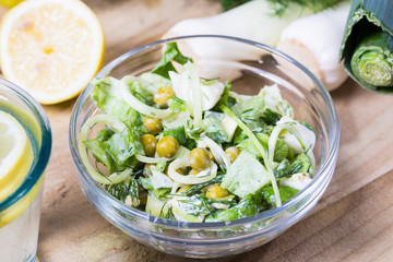 salad with fresh vegetables in glass bowl on the  table