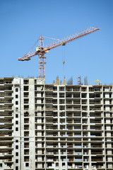 Fototapeta na wymiar Hoisting tower crane and top of construction building