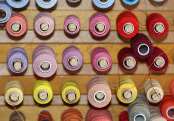 The big amount of spools with colorful threads for sewing