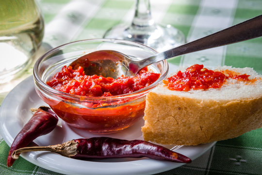 Hot sauce adjika with chili pepper and bread on the plate