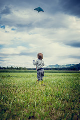 Naklejka na ściany i meble Young child flying a kite