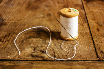 coil with white threads and a needle stuck