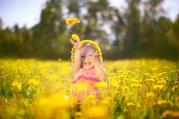Image of happy child on dandelions field, cheerful little girl r
