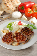 Grilled steaks on toast bread, served with onion and vegetable