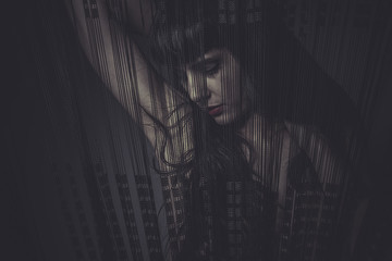Sensual naked woman behind a curtain of black threads, dream