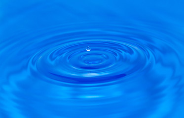 Naklejka na ściany i meble a drop of water falling in blue water