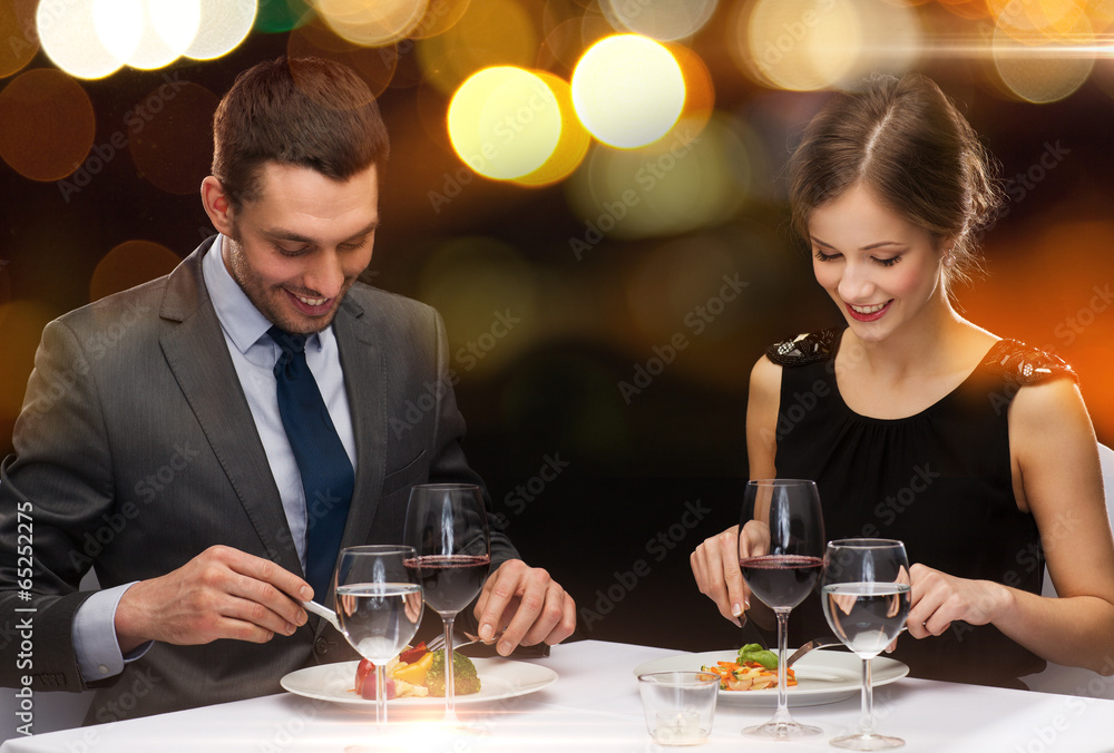 Wall mural smiling couple eating main course at restaurant