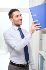 handsome businessman picking folder at office