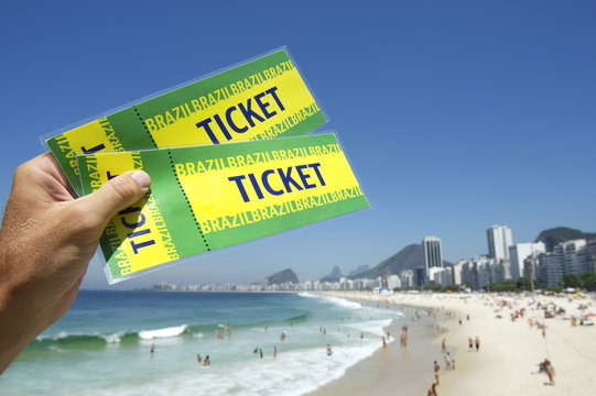Hand Holding Brazil Tickets at Copacabana Beach Rio Brazil
