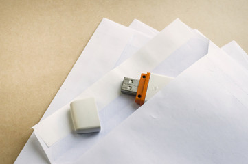 Stack of white envelopes and USB flash memory drive as concept