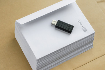 Stack of white envelopes and USB flash memory drive as concept