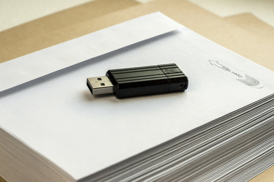 Stack of white envelopes and USB flash memory drive as concept