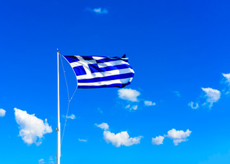 The Greek flag against the blue sky of Athens in Greece