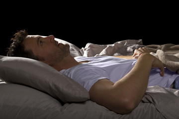 close up of insomniac unable to sleep in bed