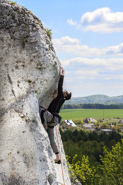  Man climbing natural difficult rocky wall.