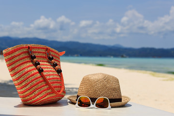 hat, bag, sun glasses on tropical beach
