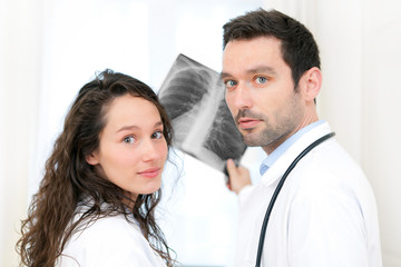 Young doctor and nurse analysing radiography