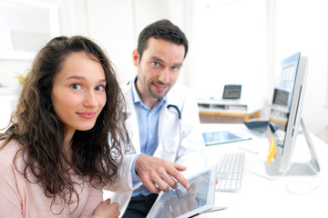 Obraz na płótnie Canvas Doctor using tablet to inform patient