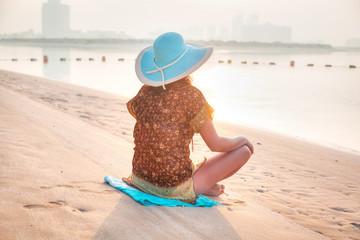 Woman at sunrise meditation on the beach