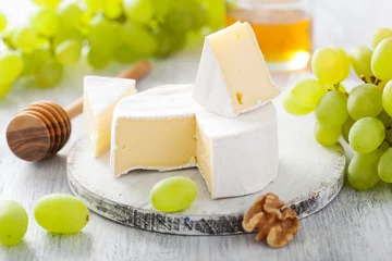 Fototapete camembert cheese with grapes, honey and nuts on wooden backgroun © Olga Miltsova
