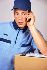Young delivery man, speaking on the mobile.