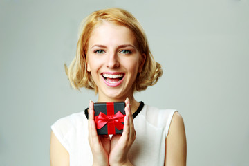 Laughing beautiful young woman holding jewelery gift box
